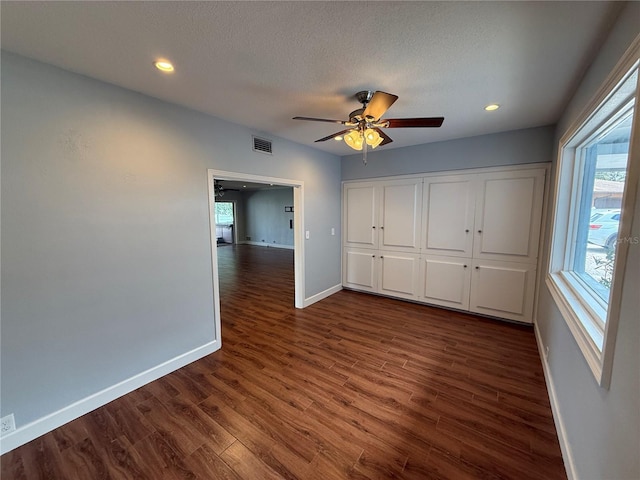 1328 Edgewater Beach Dr, Lakeland, FL 33805 - unfurnished bedroom with baseboards, multiple windows, dark wood-style floors, recessed lighting, and a textured ceiling