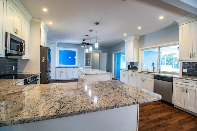 1328 Edgewater Beach Dr, Lakeland, FL 33805 - kitchen with stainless steel appliances, recessed lighting, a ceiling fan, decorative backsplash, and a center island