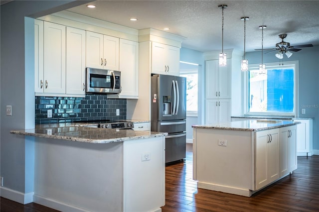 1328 Edgewater Beach Dr, Lakeland, FL 33805 - kitchen featuring stainless steel appliances, ceiling fan, backsplash, dark wood-type flooring, and white cabinets