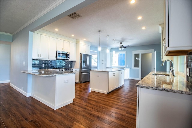 1328 Edgewater Beach Dr, Lakeland, FL 33805 - kitchen featuring stainless steel appliances, a kitchen island, a ceiling fan, a textured ceiling, and tasteful backsplash