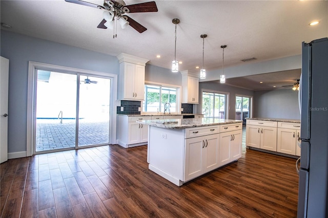 1328 Edgewater Beach Dr, Lakeland, FL 33805 - kitchen featuring ceiling fan, a center island, dark wood-style flooring, freestanding refrigerator, and recessed lighting