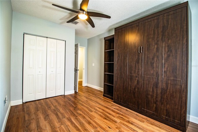 1328 Edgewater Beach Dr, Lakeland, FL 33805 - unfurnished bedroom with wood finished floors, a closet, a textured ceiling, and a ceiling fan