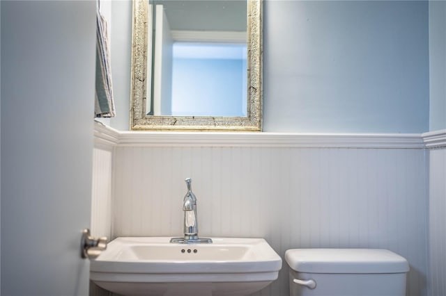 1328 Edgewater Beach Dr, Lakeland, FL 33805 - bathroom featuring toilet and a wainscoted wall