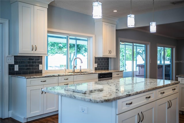 1328 Edgewater Beach Dr, Lakeland, FL 33805 - kitchen with tasteful backsplash, white cabinets, ornamental molding, a kitchen island, and light stone counters