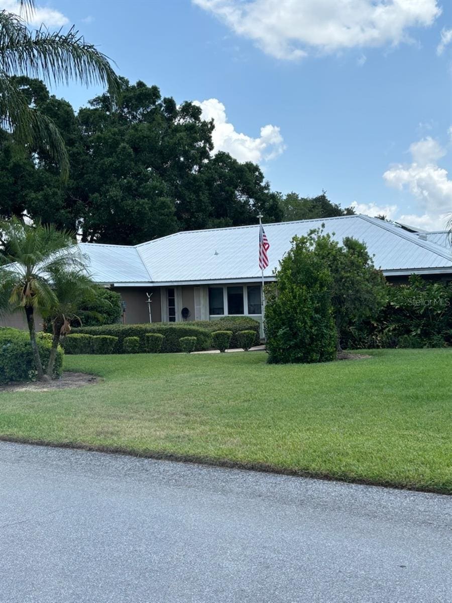 1110 Cypress Pt W, Winter Haven, FL 33884 - ranch-style house with metal roof and a front yard