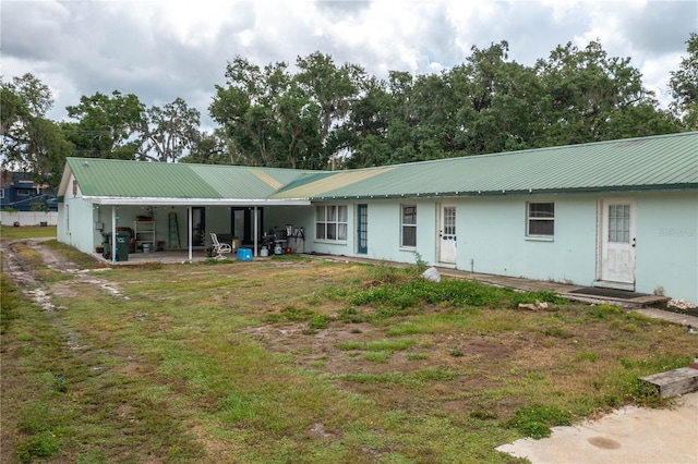 2219 New Jersey Rd, Lakeland, FL 33803 - rear view of house featuring metal roof and stucco siding