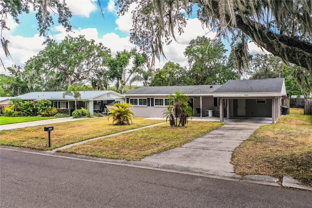 single story home featuring a front lawn, asphalt driveway, and a carport