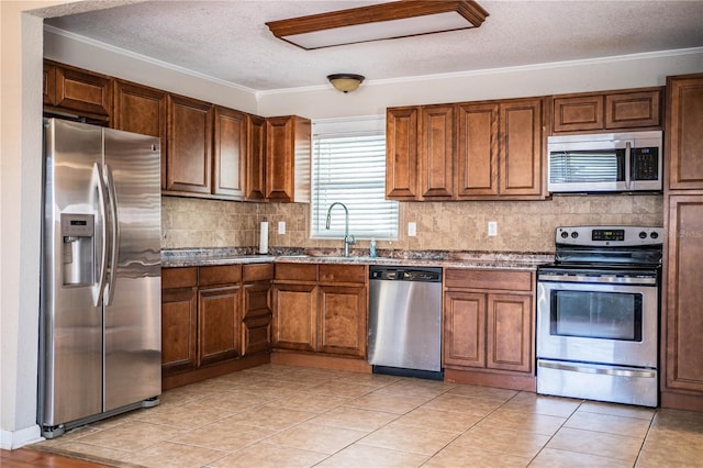 kitchen featuring appliances with stainless steel finishes, a sink, a textured ceiling, ornamental molding, and tasteful backsplash
