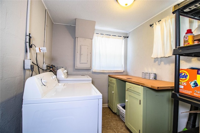 clothes washing area featuring washer and dryer, cabinet space, tile patterned flooring, a textured ceiling, and electric panel