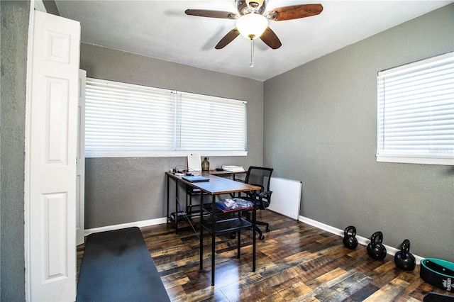 office area featuring wood finished floors, ceiling fan, a textured wall, and baseboards