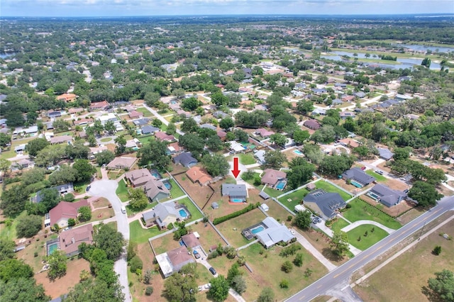 aerial view of property and surrounding area with a large body of water and nearby suburban area