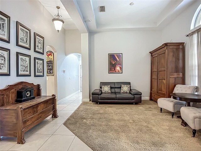 3620 Cordgrass Dr, Valrico, FL 33596 - living area featuring arched walkways, light tile patterned flooring, a tray ceiling, and baseboards