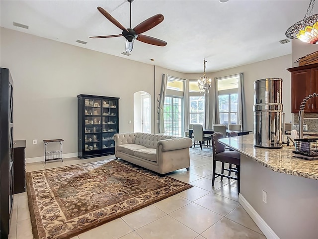 3620 Cordgrass Dr, Valrico, FL 33596 - living area with arched walkways, a ceiling fan, light tile patterned flooring, a chandelier, and baseboards