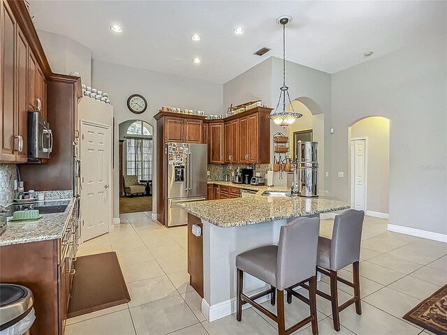 3620 Cordgrass Dr, Valrico, FL 33596 - kitchen with appliances with stainless steel finishes, arched walkways, decorative backsplash, a peninsula, and a breakfast bar