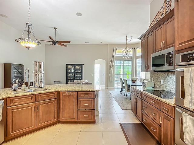 3620 Cordgrass Dr, Valrico, FL 33596 - kitchen with stainless steel appliances, a sink, arched walkways, a ceiling fan, and light tile patterned floors