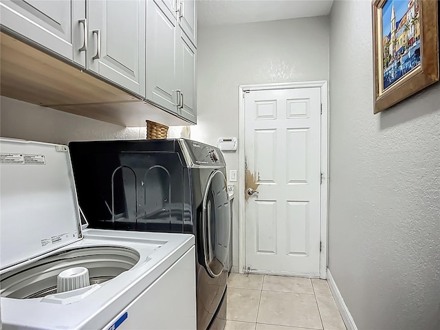 3620 Cordgrass Dr, Valrico, FL 33596 - laundry area featuring separate washer and dryer, a textured wall, light tile patterned floors, baseboards, and cabinet space