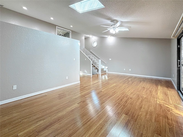 6350 92nd Pl N Unit 2206, Pinellas Park, FL 33782 - unfurnished room with stairway, a textured ceiling, wood finished floors, a skylight, and baseboards