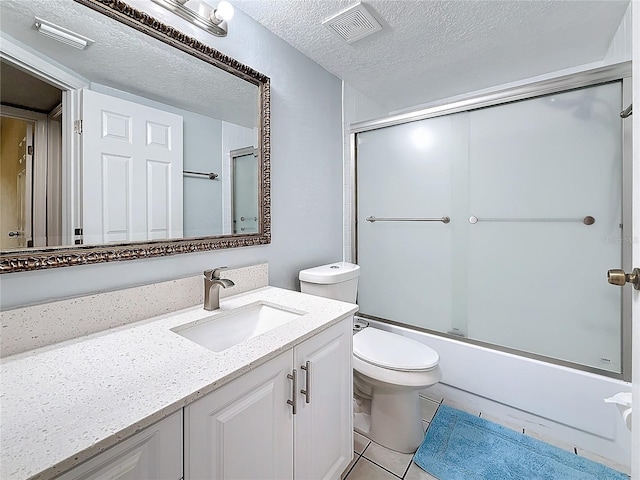6350 92nd Pl N Unit 2206, Pinellas Park, FL 33782 - full bathroom featuring vanity, toilet, enclosed tub / shower combo, tile patterned floors, and a textured ceiling