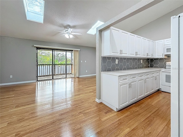 6350 92nd Pl N Unit 2206, Pinellas Park, FL 33782 - kitchen with white appliances, a skylight, light wood-style flooring, light countertops, and a textured ceiling