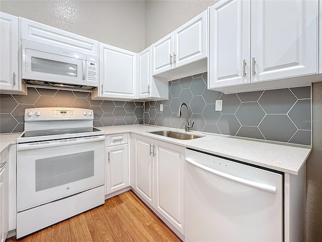 6350 92nd Pl N Unit 2206, Pinellas Park, FL 33782 - kitchen with white appliances, a sink, light wood-style floors, decorative backsplash, and white cabinets