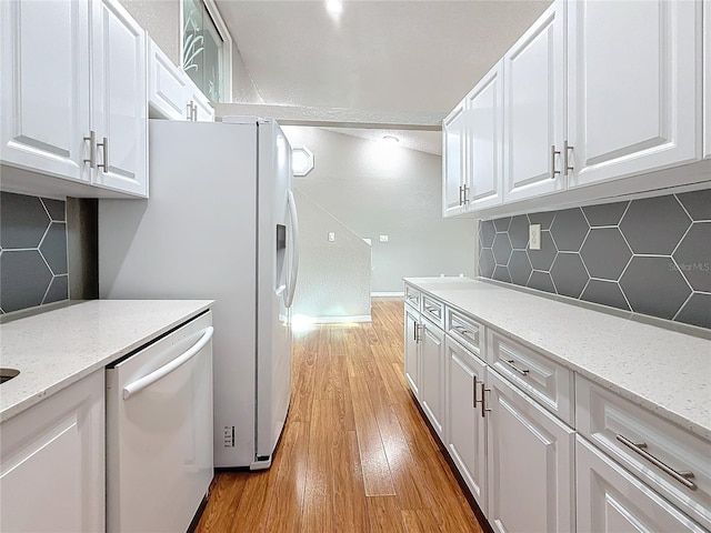 6350 92nd Pl N Unit 2206, Pinellas Park, FL 33782 - kitchen featuring white dishwasher, white cabinetry, decorative backsplash, light wood-style floors, and light stone countertops