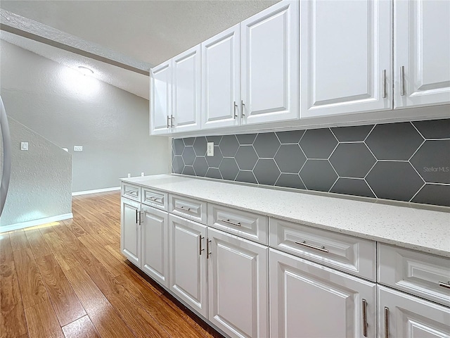 6350 92nd Pl N Unit 2206, Pinellas Park, FL 33782 - kitchen featuring decorative backsplash, white cabinets, and light wood-type flooring