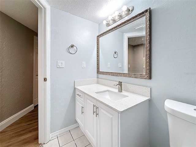 6350 92nd Pl N Unit 2206, Pinellas Park, FL 33782 - bathroom featuring vanity, a textured ceiling, toilet, tile patterned flooring, and a textured wall