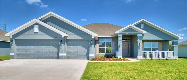 single story home featuring a front lawn, driveway, a garage, stucco siding, and a porch