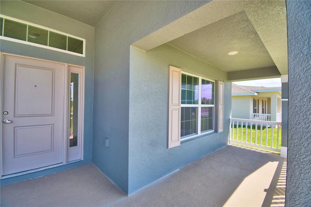 view of exterior entry with stucco siding