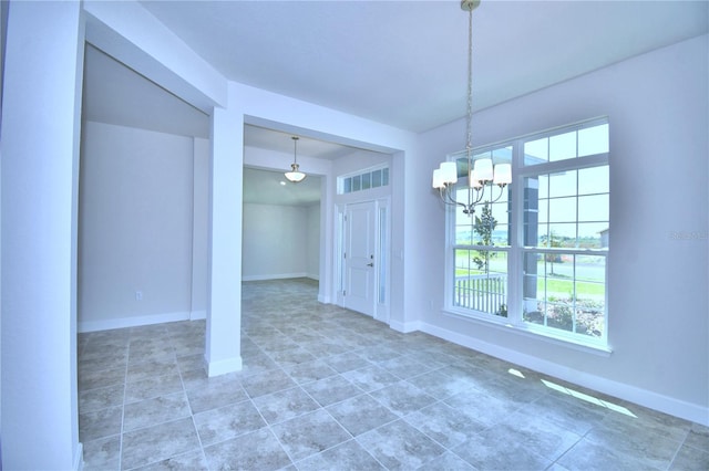 unfurnished dining area with a chandelier, plenty of natural light, baseboards, and tile patterned floors