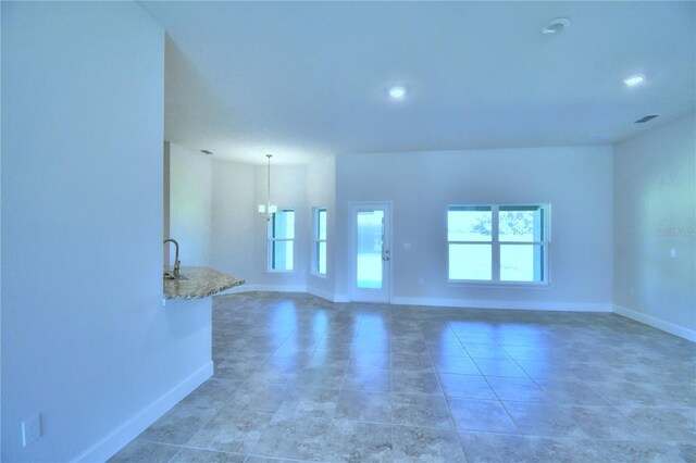 unfurnished living room featuring baseboards, recessed lighting, and light tile patterned floors