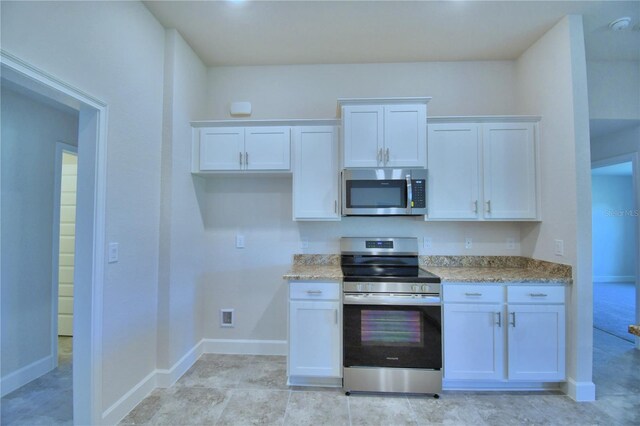 kitchen with stainless steel appliances, white cabinetry, baseboards, and light stone counters