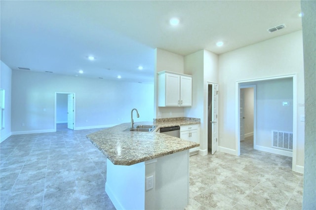 kitchen featuring a sink, white cabinets, recessed lighting, a peninsula, and light stone countertops