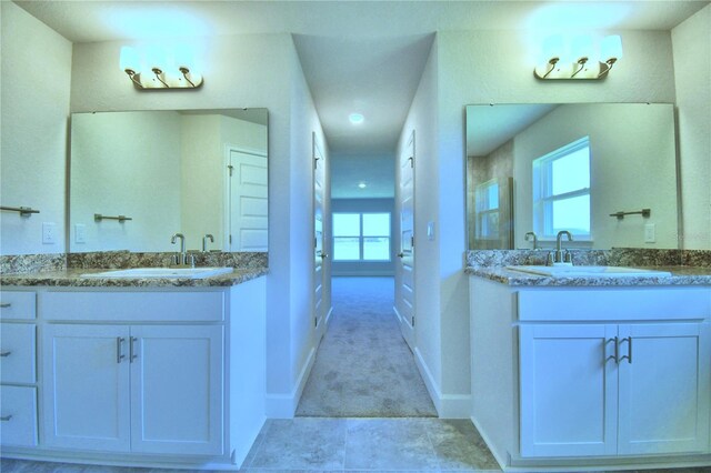 full bathroom with two vanities, baseboards, a shower, and recessed lighting