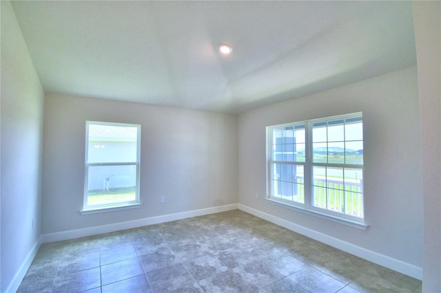 unfurnished room with baseboards and tile patterned floors