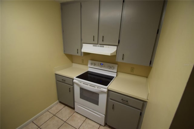 6054-6066 Hilltop Ln W, Lakeland, FL 33809 - kitchen featuring under cabinet range hood, white electric range oven, gray cabinetry, baseboards, and light tile patterned floors