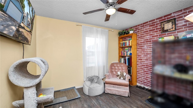 417 Yolonda Ct, Lakeland, FL 33809 - living area featuring wood finished floors, a textured ceiling, a ceiling fan, and brick wall