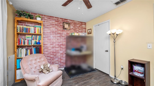 417 Yolonda Ct, Lakeland, FL 33809 - sitting room with wood finished floors, a textured ceiling, ceiling fan, and brick wall
