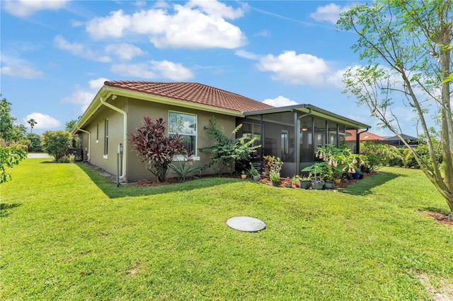 5033 Sugar Bay St, Sebring, FL 33872 - rear view of house featuring a sunroom, stucco siding, a lawn, and a tiled roof