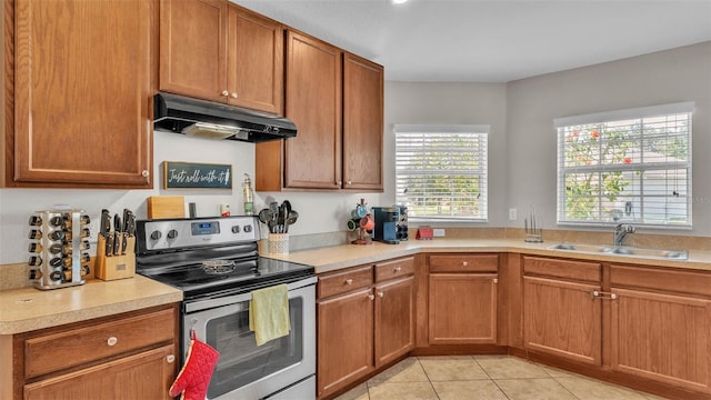 kitchen featuring stainless steel electric range, a sink, under cabinet range hood, light countertops, and light tile patterned floors