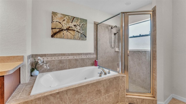 bathroom featuring a shower stall and a jetted tub
