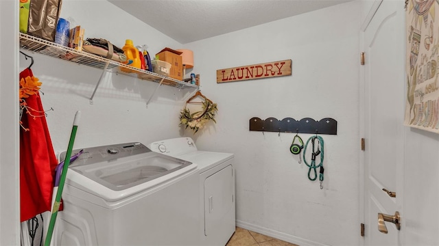 laundry room featuring washing machine and clothes dryer and light tile patterned flooring