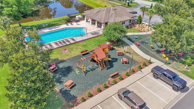 aerial view of property and surrounding area with a pool and a nearby body of water