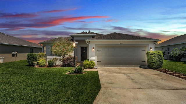 view of front of house with stucco siding, a garage, concrete driveway, and a front lawn