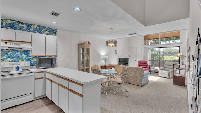 30 Aspen Dr Unit 30, Haines City, FL 33844 - kitchen featuring electric stove, under cabinet range hood, black microwave, a peninsula, and light countertops
