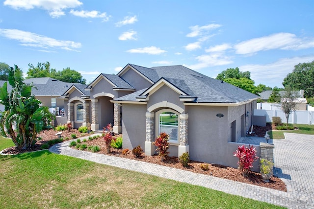 2032 Indian Sky Cir, Lakeland, FL 33813 - view of front of property with stucco siding, stone siding, driveway, and roof with shingles
