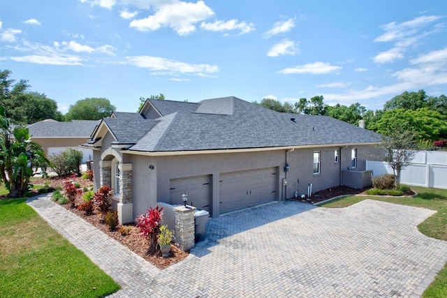 2032 Indian Sky Cir, Lakeland, FL 33813 - view of front of house featuring stucco siding, an attached garage, driveway, and a shingled roof