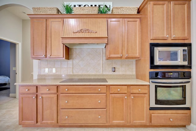 2032 Indian Sky Cir, Lakeland, FL 33813 - kitchen with appliances with stainless steel finishes, backsplash, baseboards, light tile patterned floors, and brown cabinetry