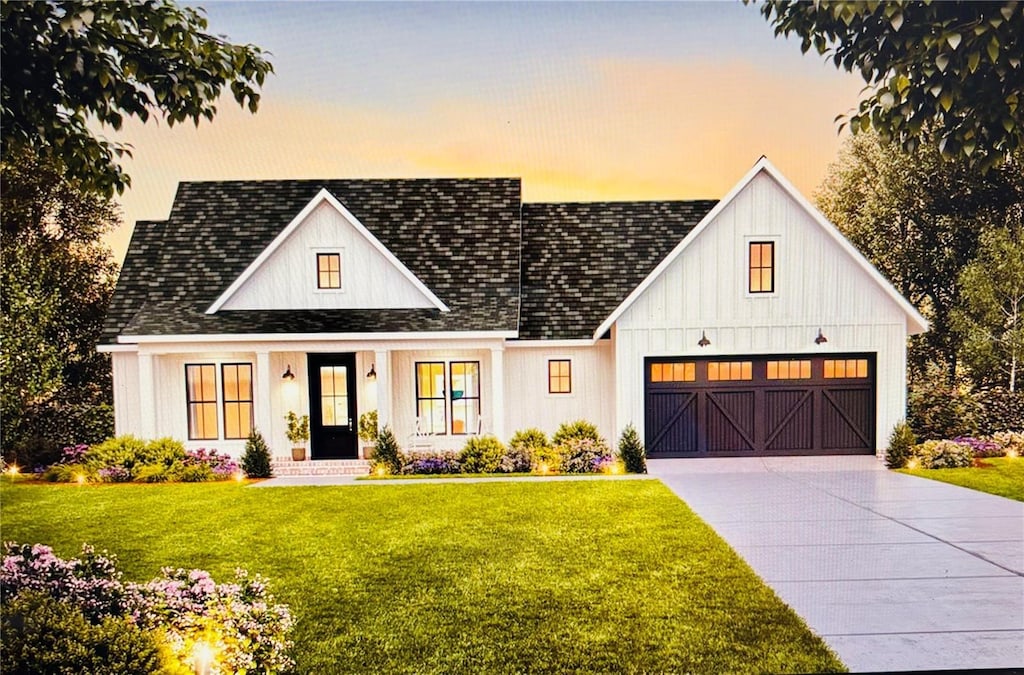 modern farmhouse style home featuring concrete driveway, a lawn, a garage, a shingled roof, and board and batten siding