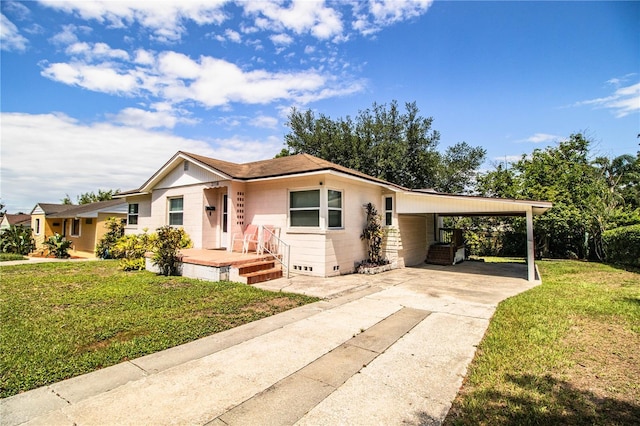 2710 Fairmount Ave, Lakeland, FL 33803 - view of front facade with an attached carport, a front yard, and concrete driveway